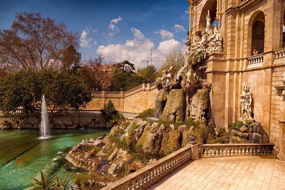 A fountain, a statue, and a building with columns.
