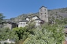 Església amb un campanar i una muntanya de fons.