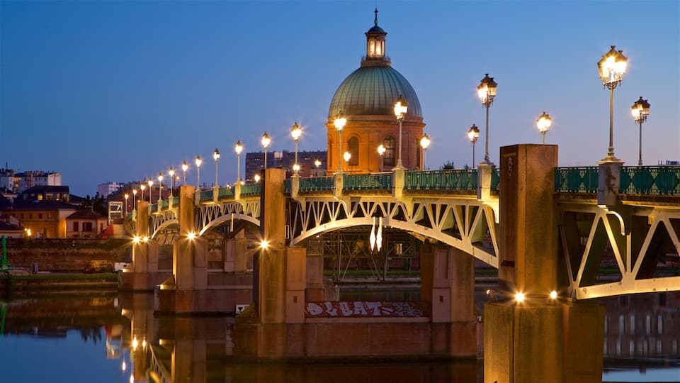 A bridge with street lamps and a domed building in the background.