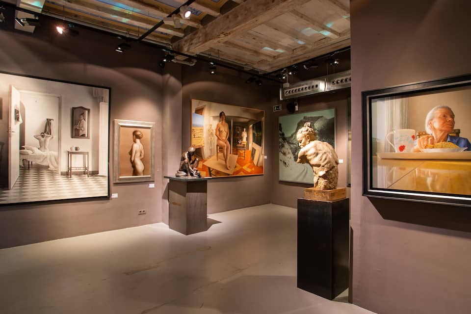 An art gallery with various paintings and sculptures on display.