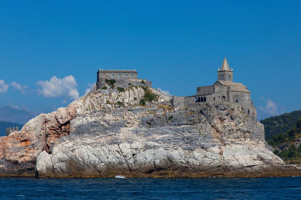 A rocky island with a stone building and a bell tower.