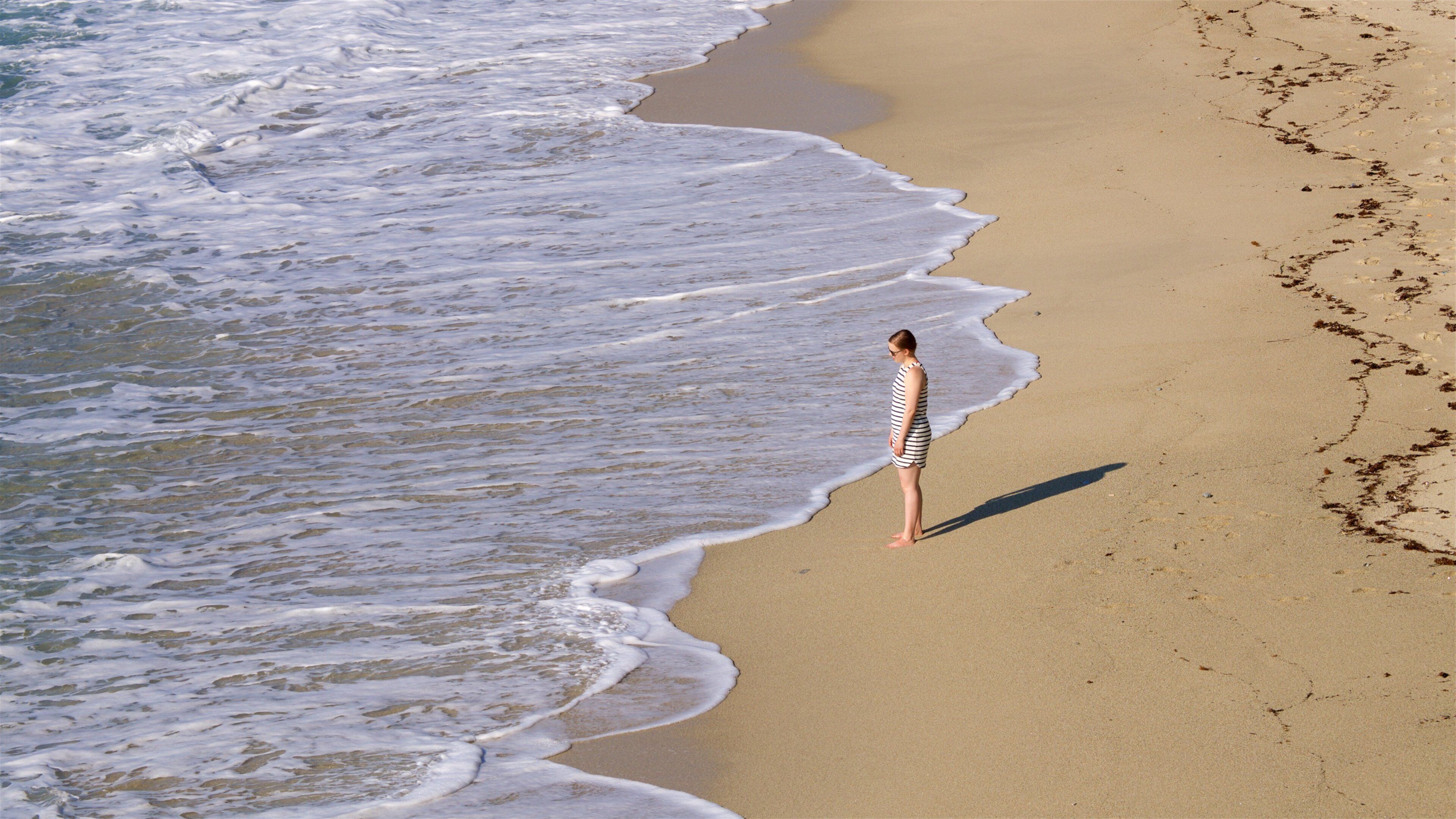 Michelino Beach showing general coastal views and a beach as well as an individual femail