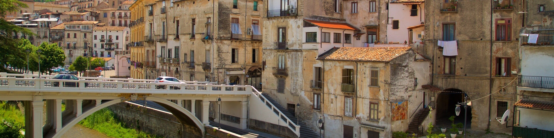 A bridge over a river, surrounded by historic buildings with red-tiled roofs.