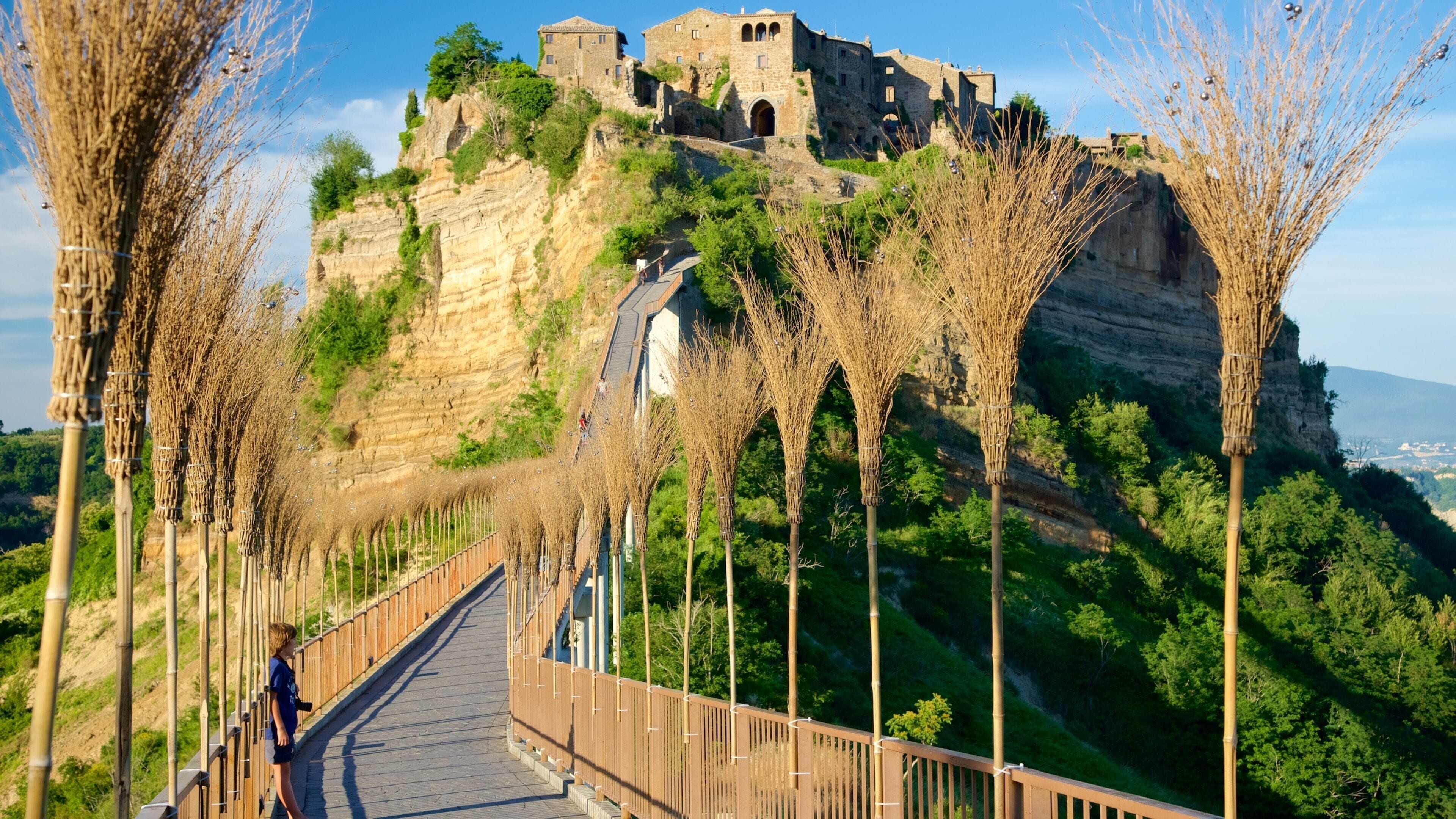 A stone castle on a hill with a wooden bridge.