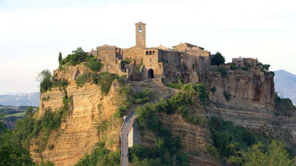 A historic stone castle atop a cliff with a winding road leading up.