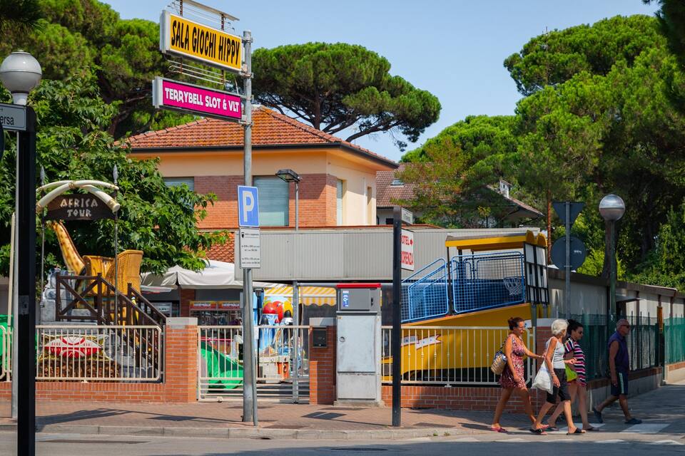 Eine Straße mit einem Schild für Sala Giochi Hippy, einem Terrybell Slot & VLT, und einem Parkschild.