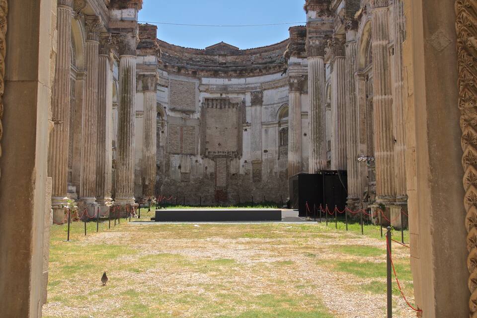 Un ancien amphithéâtre romain, doté de colonnes et d’une scène centrale.