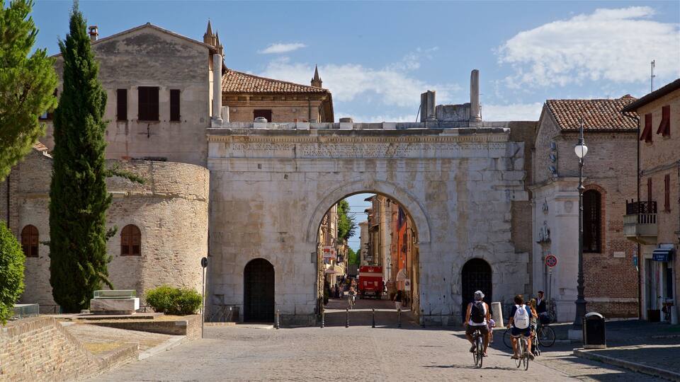 Arco di Augusto che include bicicletta e oggetti d\'epoca cosi come coppia