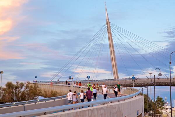 Ponte del Mare ofreciendo un puente y un atardecer y también un grupo pequeño de personas