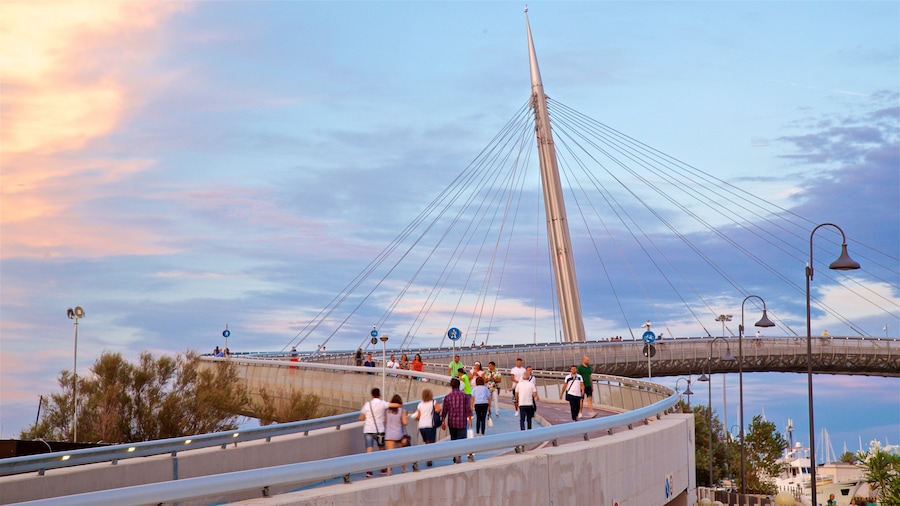 Ponte del Mare che include ponte e tramonto cosi come un piccolo gruppo di persone