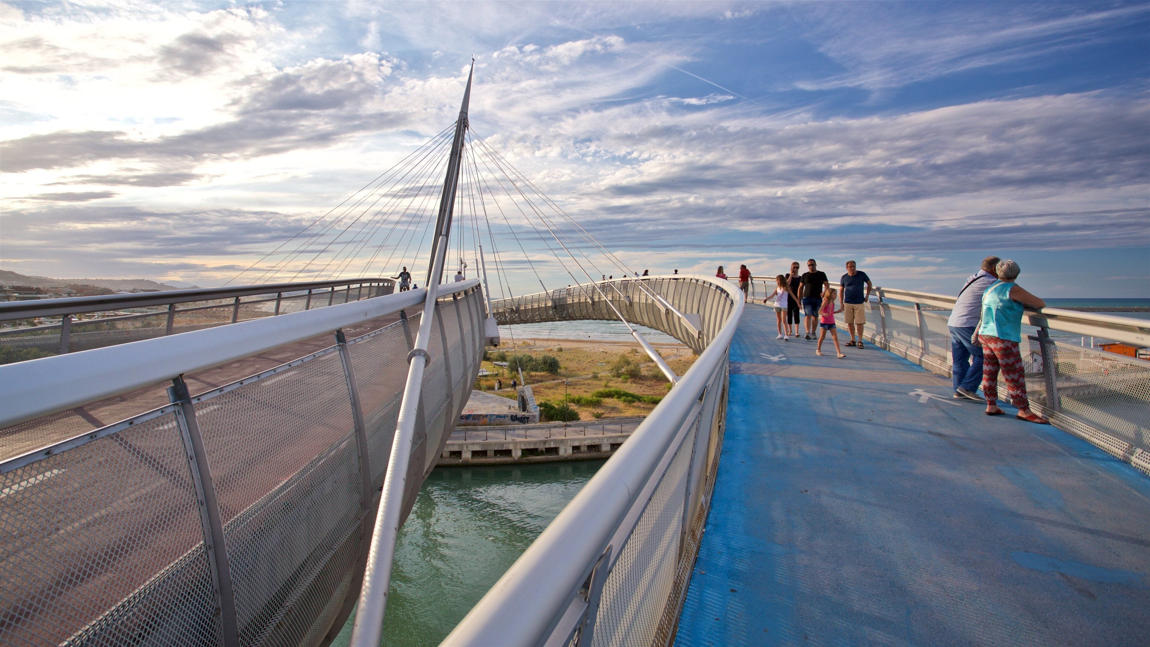 Ponte del Mare showing a bridge and a sunset as well as a small group of people