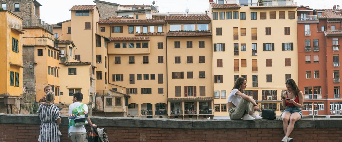 A group of people on a bridge with buildings in the background.