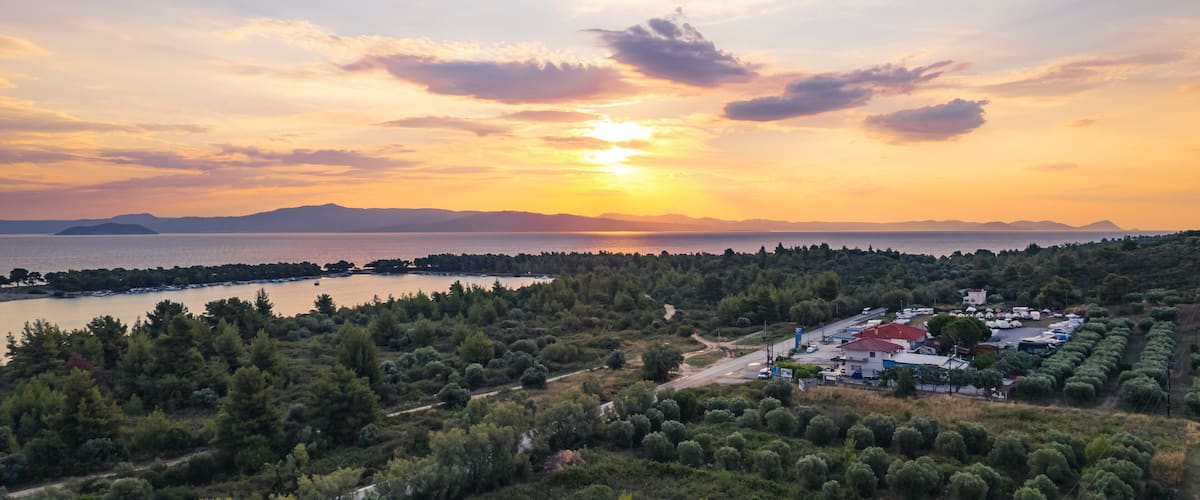 Glarokavos beach and port near Pefkochori village. Gentle sand, shallow waters, and pine trees. Amazing sky colors during sunset. High quality photo