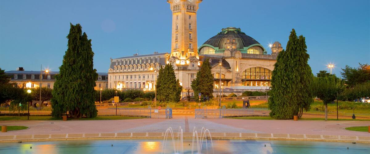 A historic building with a clock tower and a fountain in front.
