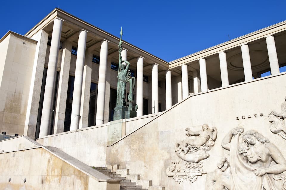 A building with classical architecture, including columns and a statue.