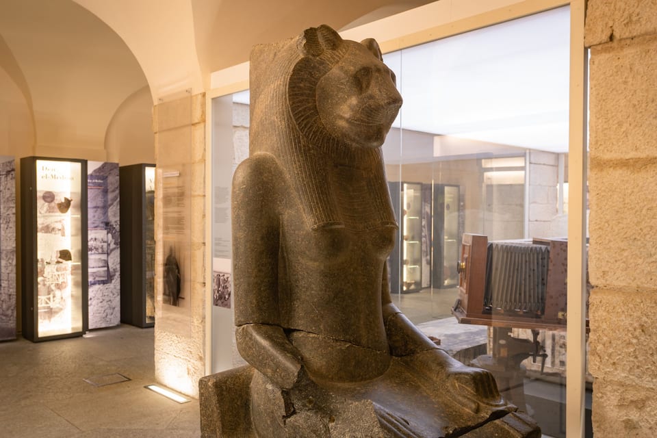A stone sphinx statue in a museum.