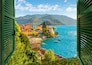 View through an open window with shutters looking down on the colorful picturesque village of Varenna, Italy, on the shores of Lake Como at summer.