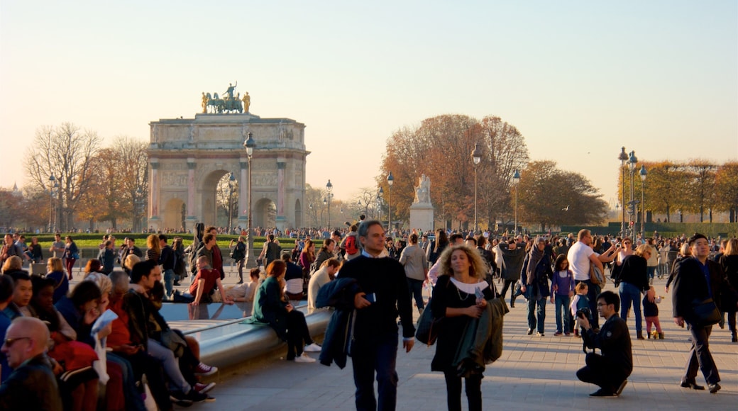 Arc de Triomphe du Carrousel which includes heritage elements and a sunset as well as a large group of people