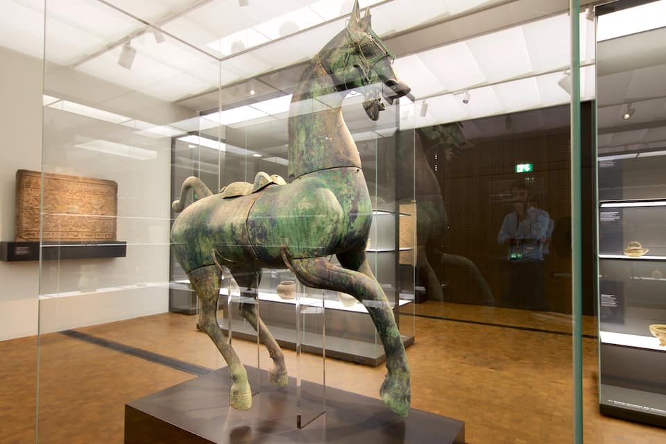 A bronze horse statue in a museum.