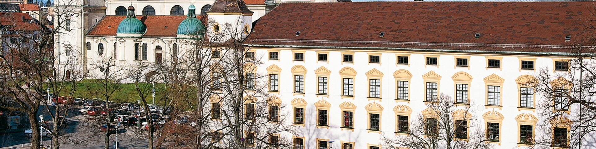 Un bâtiment historique doté de coupoles vertes et d’une tour horloge.