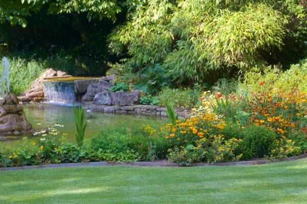 Luxemburg das einen Teich, Blumen und Springbrunnen