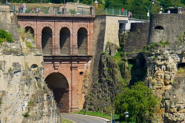 A historic stone bridge with arches, a stone wall, and a pathway.