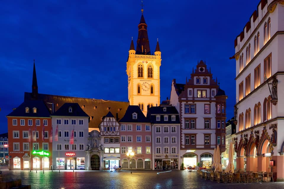 A historic square with a prominent clock tower, traditional buildings, and a cobblestone street.