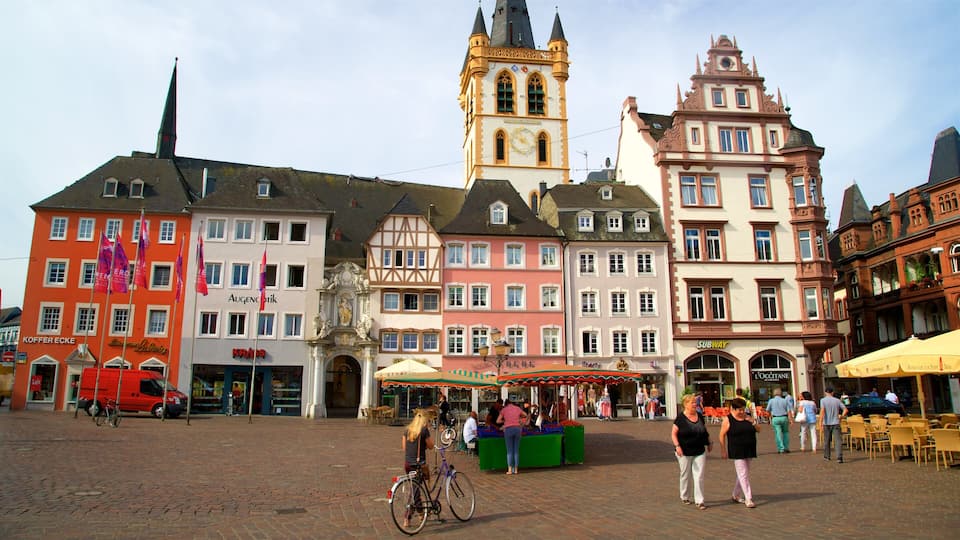 Una plaça europea històrica amb edificis de colors, una torre del rellotge i una zona de mercat.