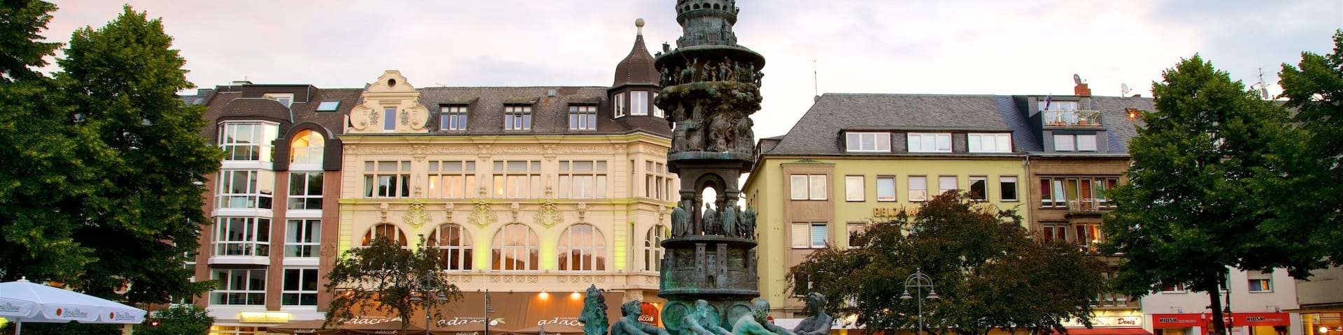 Una fuente histórica con estatuas en una plaza pública rodeada de edificios europeos tradicionales.