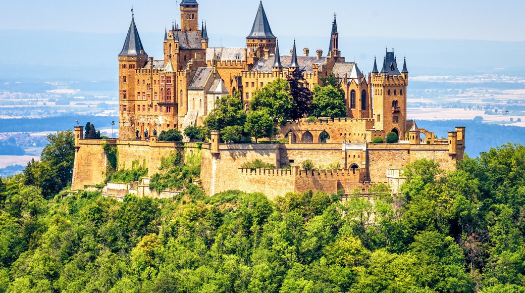 Hohenzollern Castle on mountain top close-up, Germany. Fairytale castle is famous landmark near Stuttgart. Scenic view of mount Burg Hohenzollern in forest.