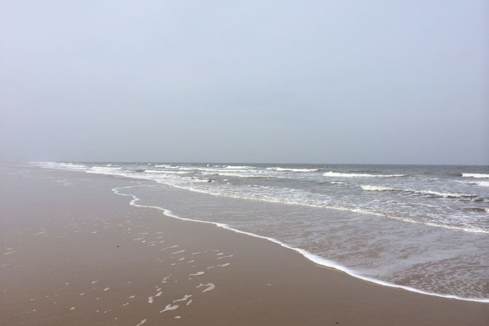 A beach with waves gently lapping onto the shore.