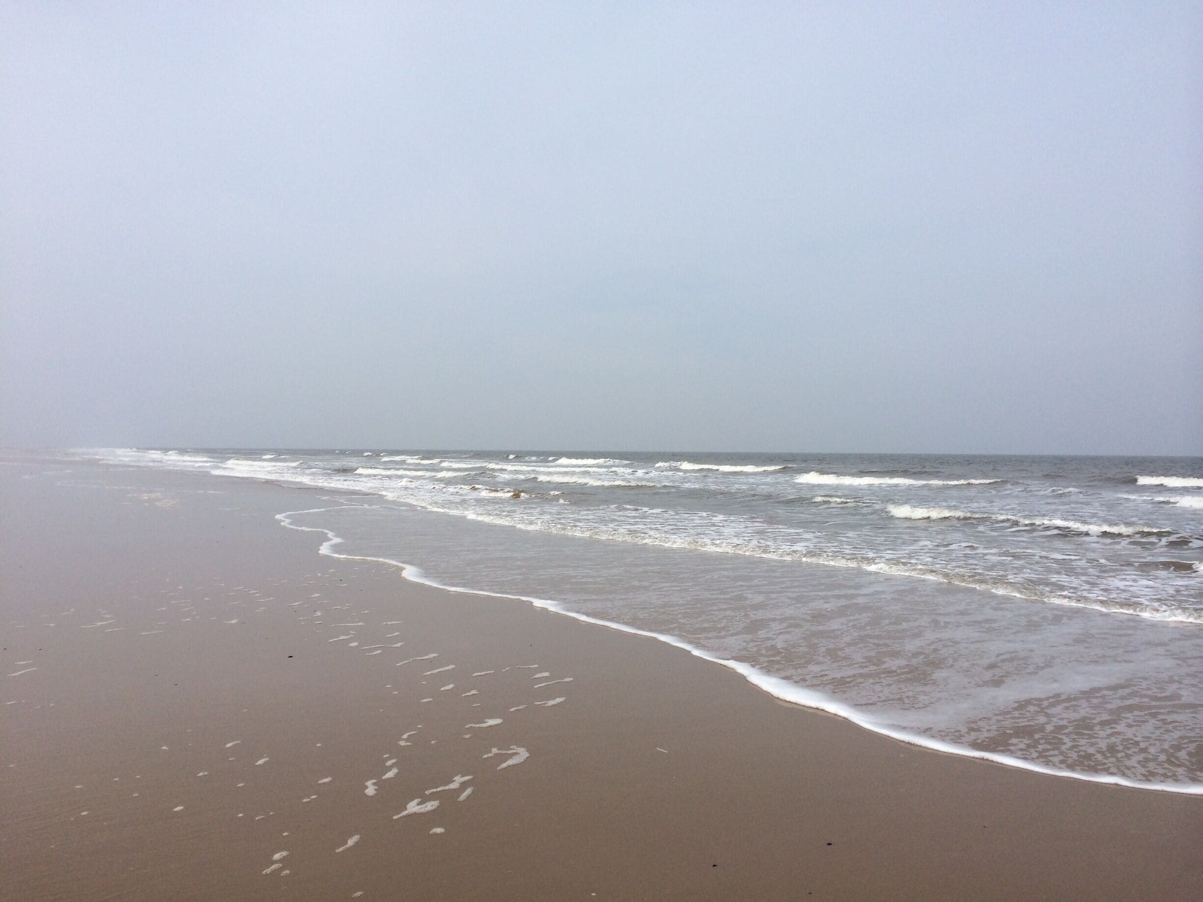 A beach with waves gently lapping onto the shore.