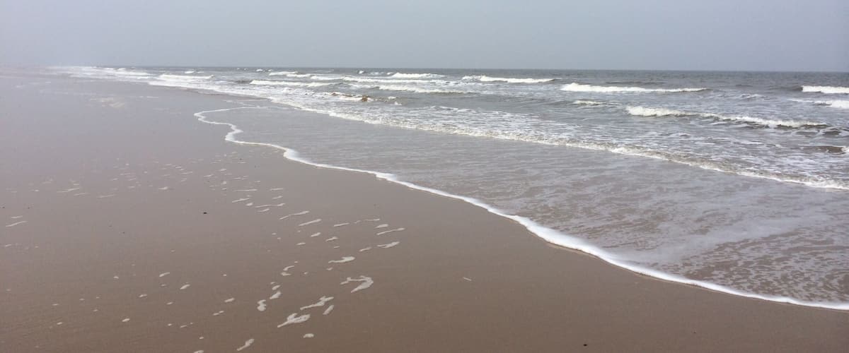 A beach with waves gently lapping onto the shore.