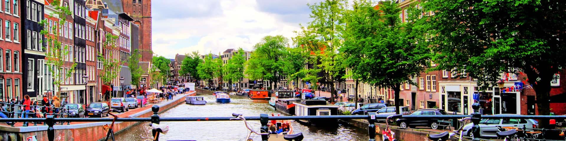 A canal with boats, bicycles, and historic buildings.