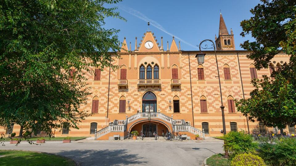 A historic building with a clock tower, arched windows, and a central entrance.
