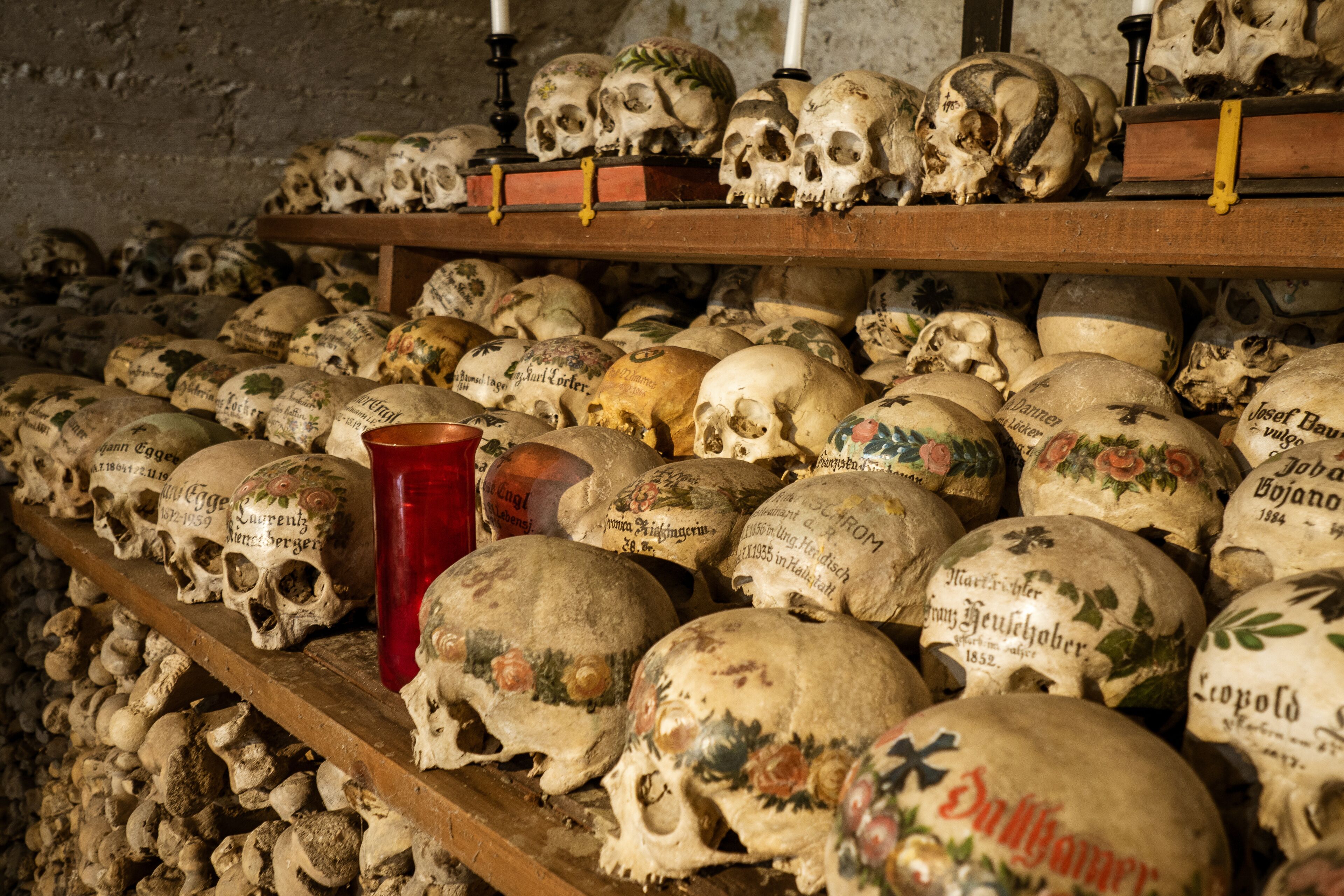 View of hundreds of painted skulls and bones inside the famous charnel house at the mountain village Hallstatt in the Salzkammergut region, Austria