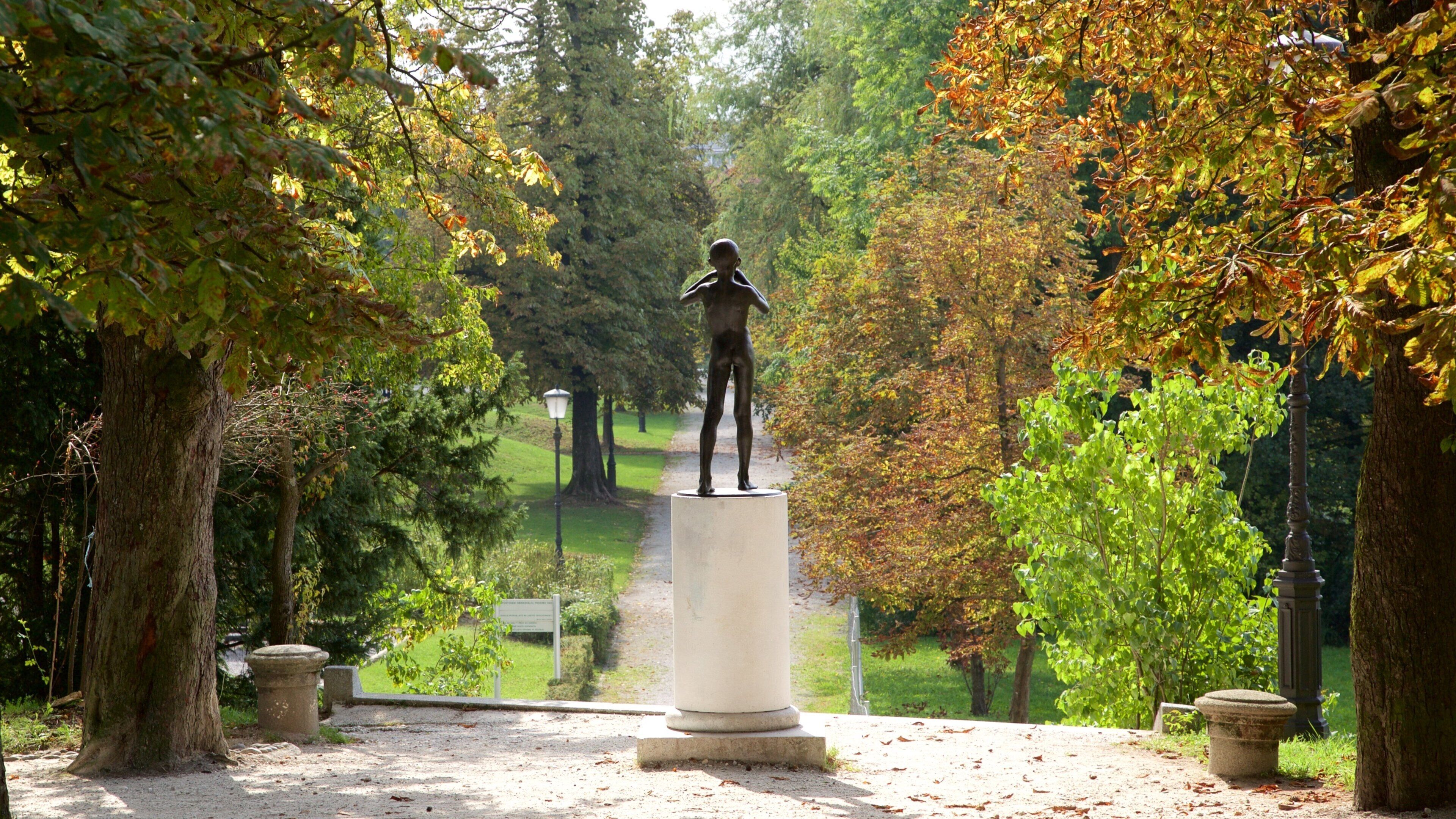 Liubliana caracterizando folhas de outono, um parque e uma estátua ou escultura