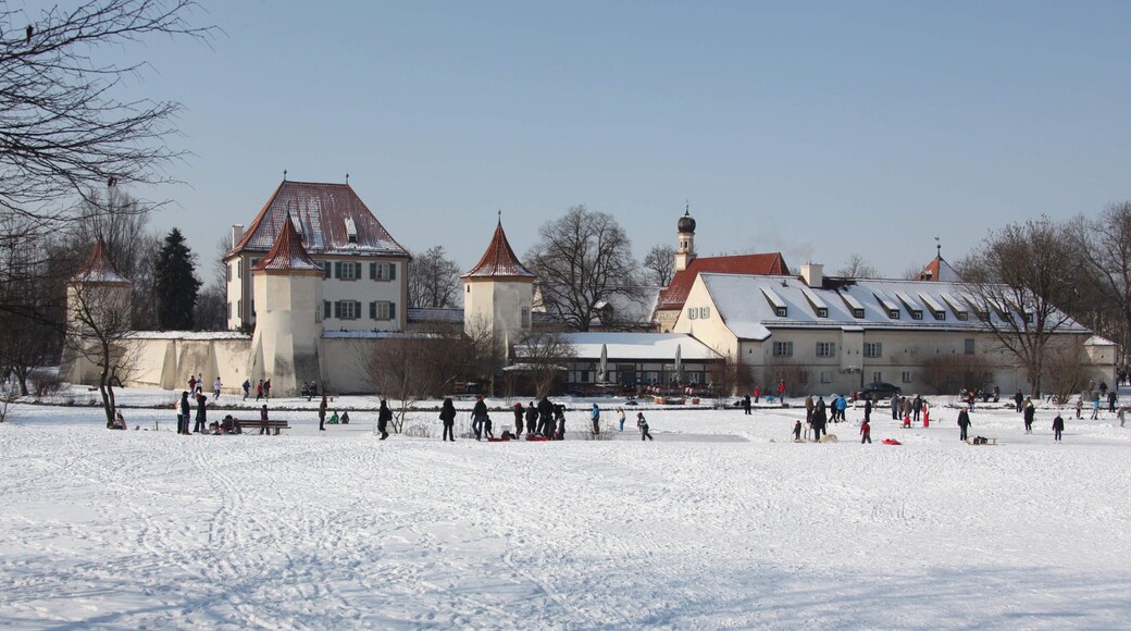 Blutenburg Castle showing snow and a small town or village as well as a small group of people
