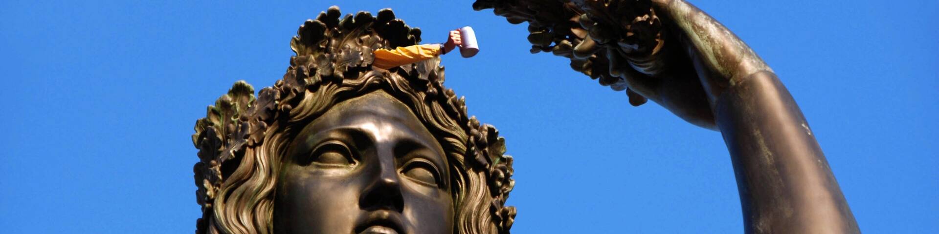 Una estatua con una mano sosteniendo una rama.