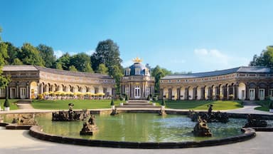 Um palácio imponente com uma fonte central e jardins simétricos.