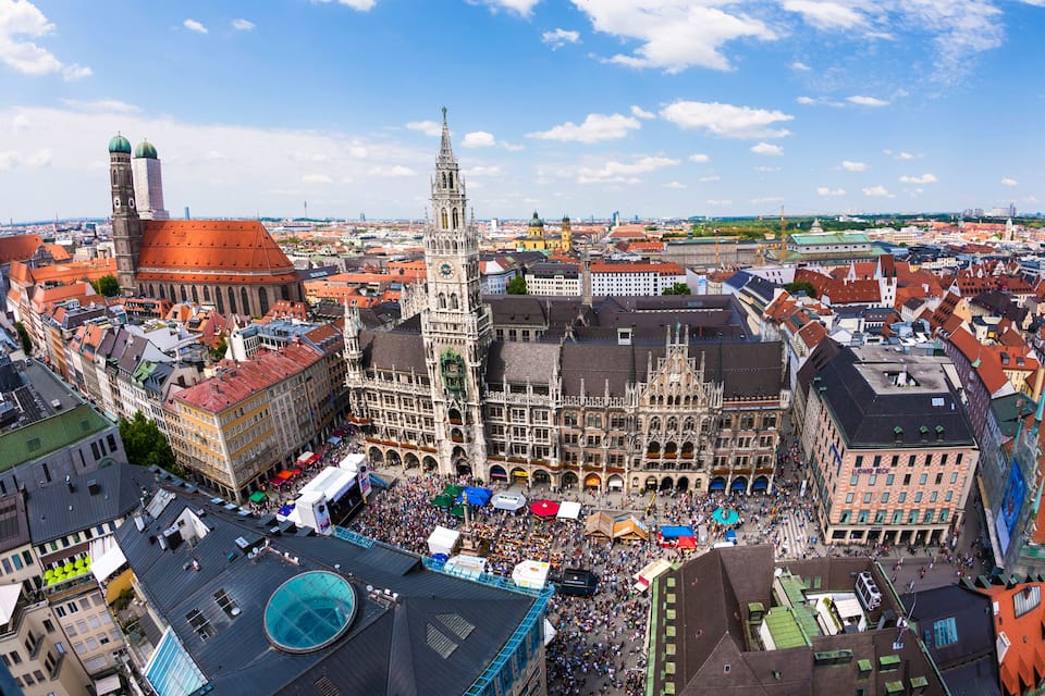 A historic city square with a prominent clock tower and surrounding buildings.