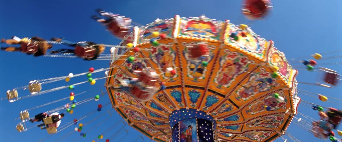 Germany, Bavaria, Munich, people on carousel swings, Oktoberfest