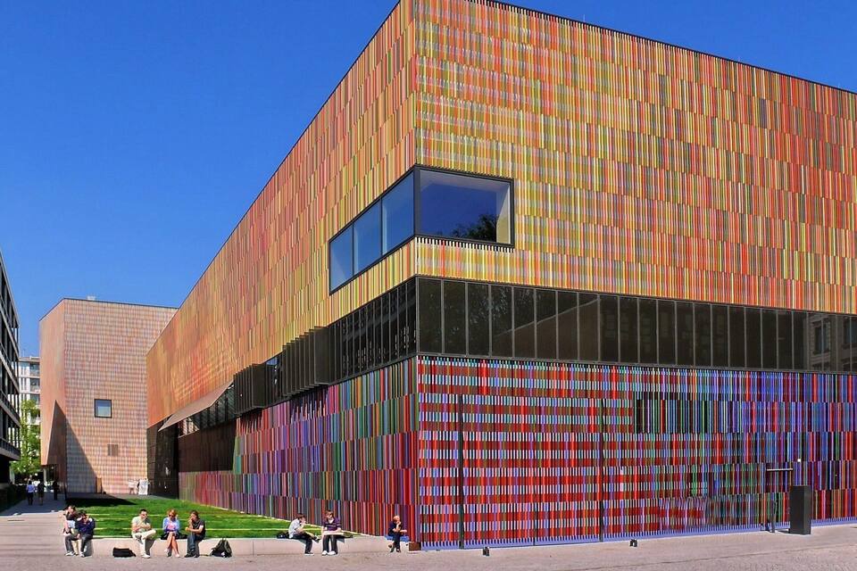 A modern building with a colorful facade and a large glass window.