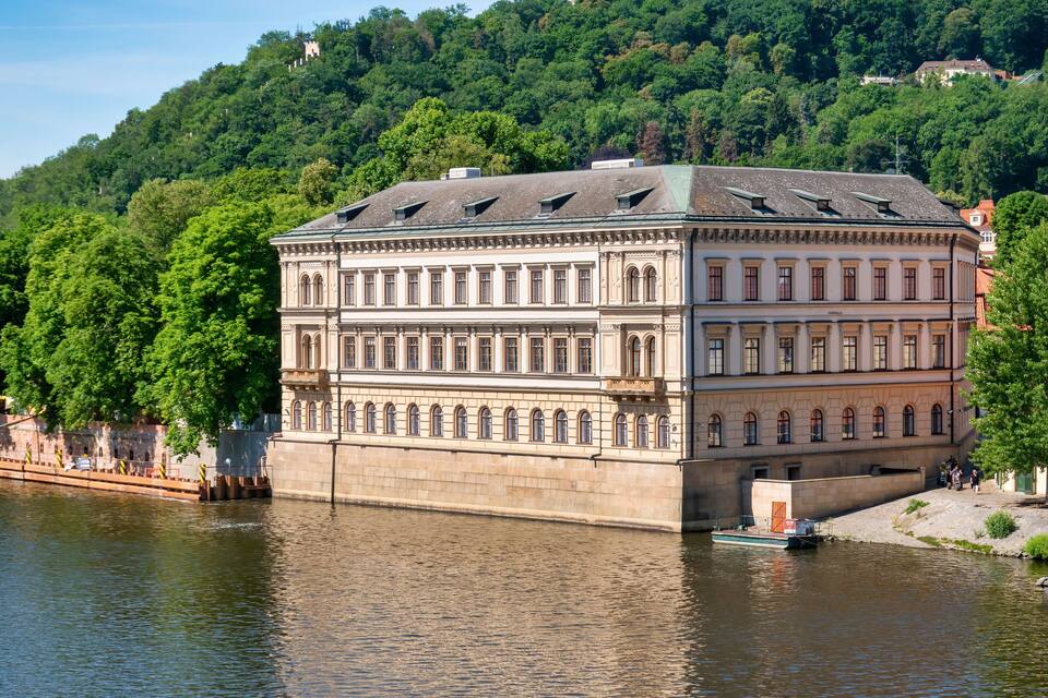 A historic building with a river in front.