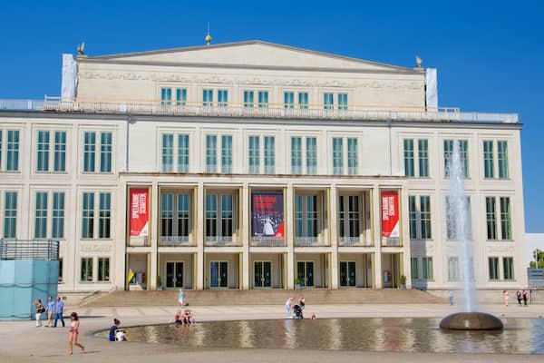 A large classical building with a fountain in front.