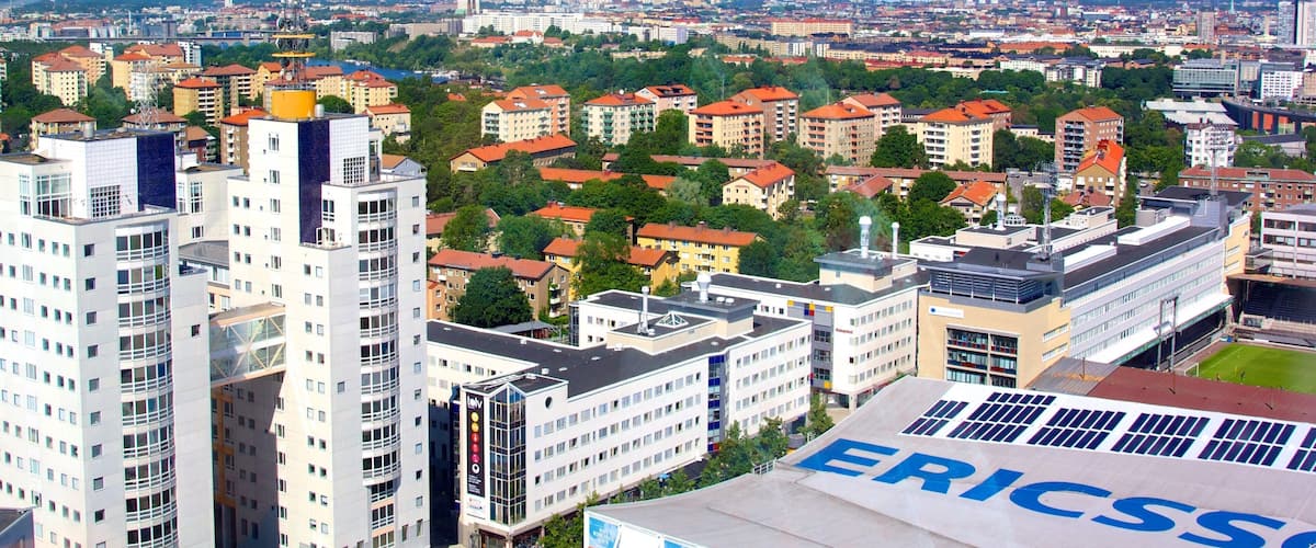 A cityscape with modern buildings, a stadium, and a clear sky.