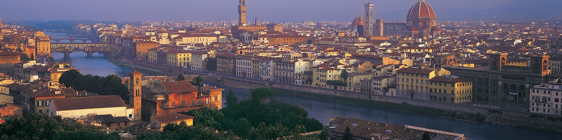 Une vue panoramique d’une ville historique, avec une cathédrale imposante, une rivière et un pont.