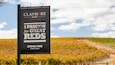 A sign for Claymore Wines in Clare Valley, Joshua Tree Vineyard, with a vineyard in the background.