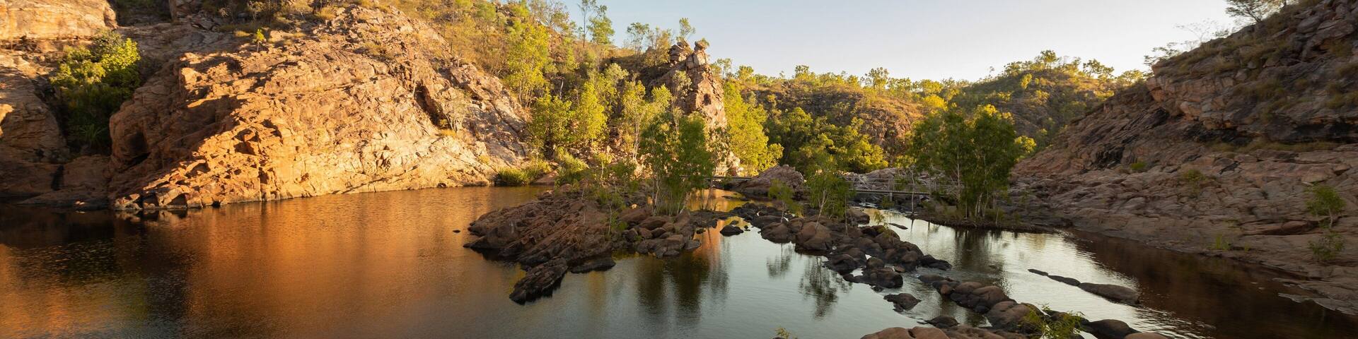 A river with rocky banks and sparse vegetation.