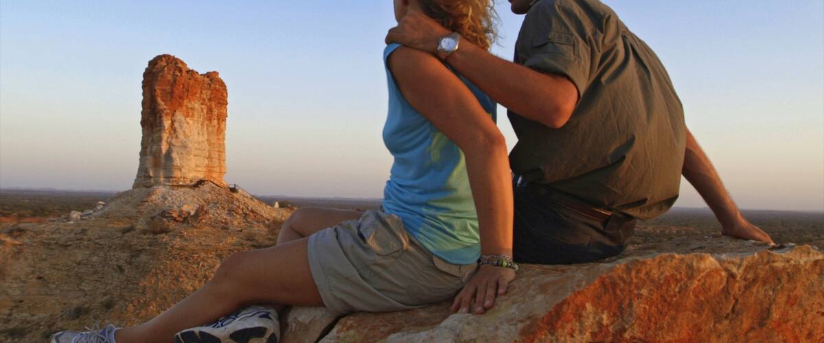 Chambers Pillar which includes a sunset, desert views and a gorge or canyon